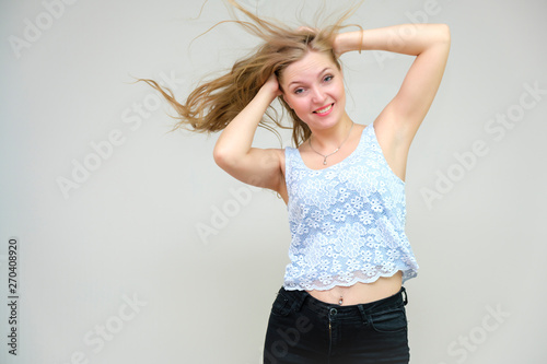 Life is beautiful and I like everything here. I am satisfied with life and I wish you. Portrait of a smiling beautiful blonde girl on a gray background in various poses.