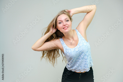 Life is beautiful and I like everything here. I am satisfied with life and I wish you. Portrait of a smiling beautiful blonde girl on a gray background in various poses.