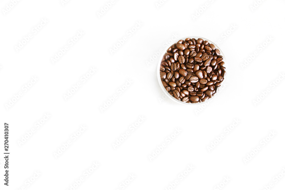 Roasted Arabica beans in a round glass bowl on a light surface Roasted Arabica beans in a round glass bowl on a light surface