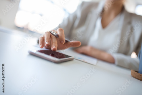 business, technology and people concept - close up of hand of businesswoman using smartphoner at office