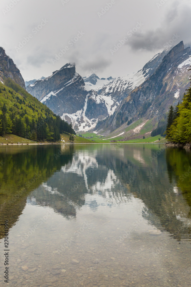 lake Seealpsee, mirrored snowcapped mountain, clouds