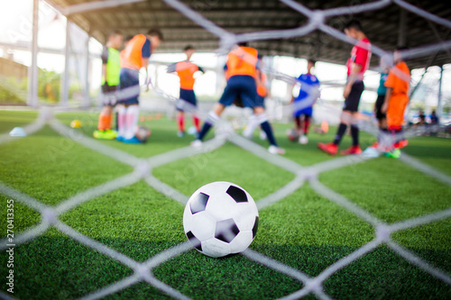 selective focus to football is in goal with blurry white mesh goal