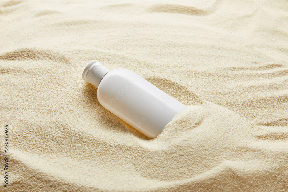 sunblock moisturizing lotion in white bottle in sand sunblock moisturizing lotion in white bottle in sand