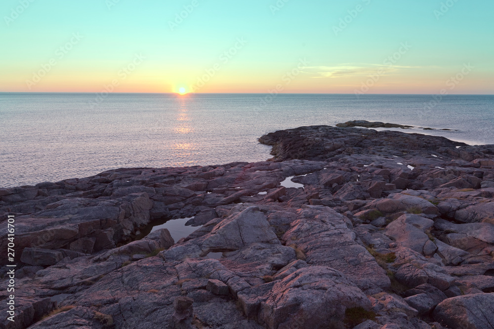 Rocky beach on the shore of the Barents Sea at sunset