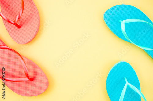 Frame mockup red and blue beach slippers isolated on a pastel beige background. Top view with copy space