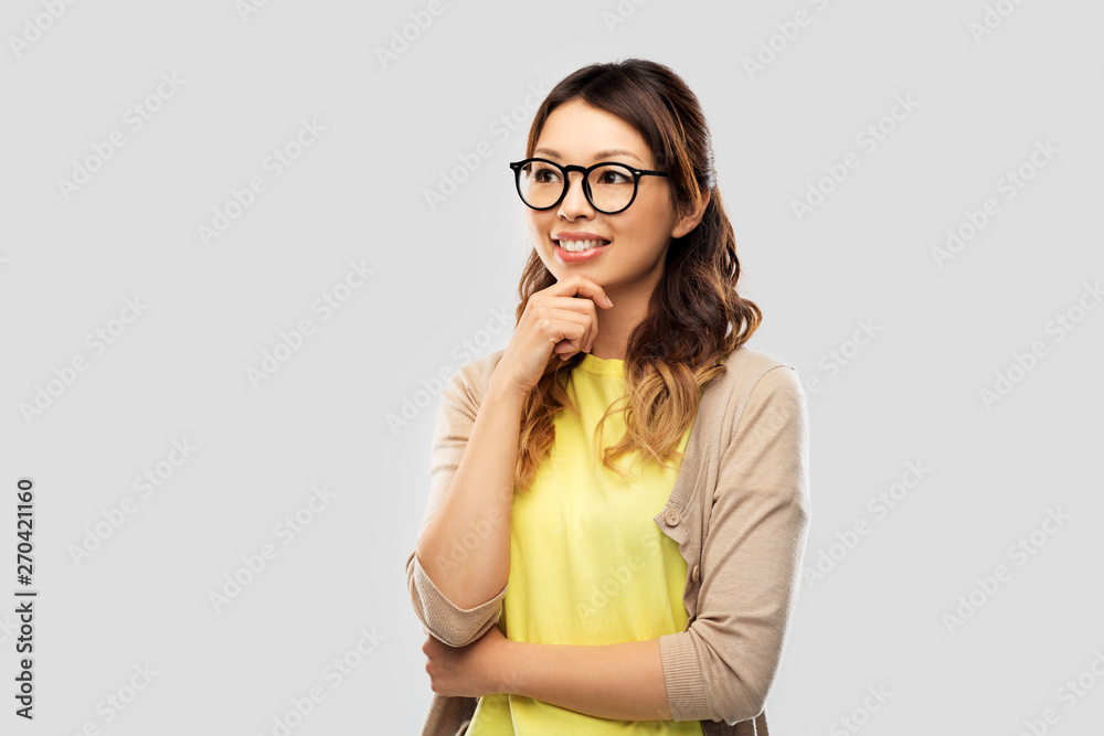 people, education and school concept - happy asian woman in glasses or student over grey background