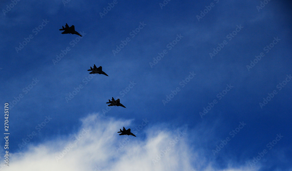 Obraz premium A group of fighters is flying in the blue sky