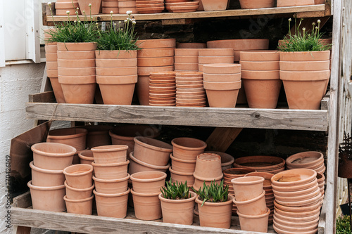 Terracotta clay pots for garden plants and flowers. Decorative flower pots and vases outside. Flower business © Elena Sistaliuk