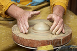 Closeup of an artisan hand making a jug of clay on a craft circle.