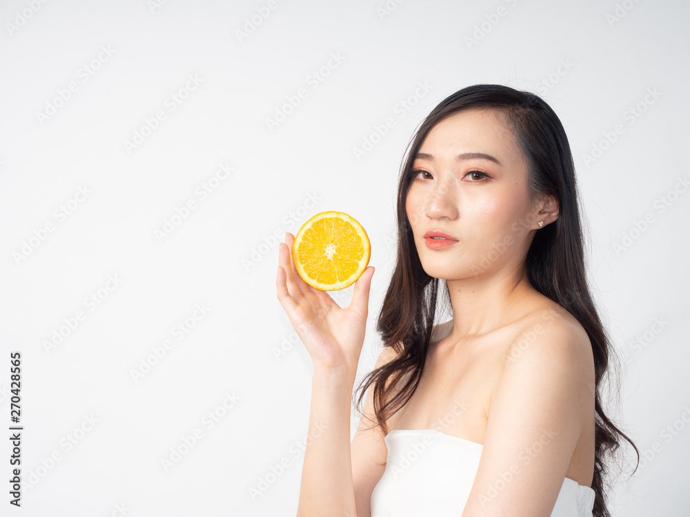 portrait asian beautiful woman.Closeup beauty skin face young girl.isolated white background. female holding orange portrait asian beautiful woman.Closeup beauty skin face young girl.isolated white background. female holding orange
