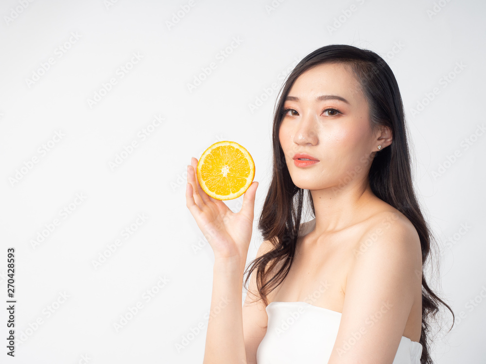portrait asian beautiful woman.Closeup beauty skin face young girl.isolated white background. female holding orange portrait asian beautiful woman.Closeup beauty skin face young girl.isolated white background. female holding orange