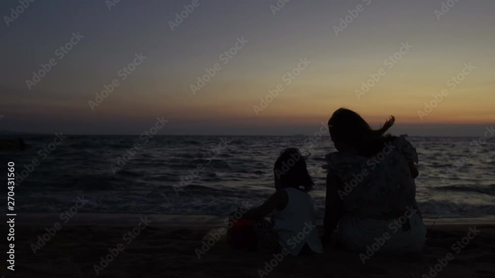 Asian mother and daughter play together at seaside on sunset,Thailand people