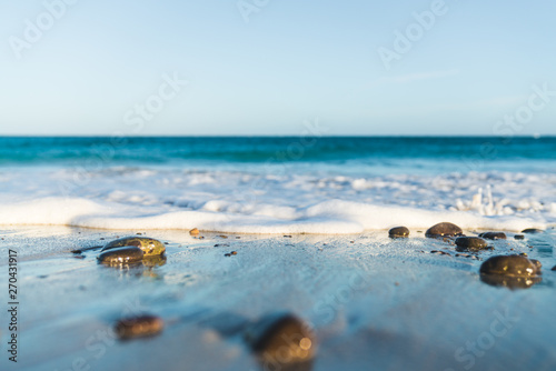 Waves reaching stones and sand in a tropical beach