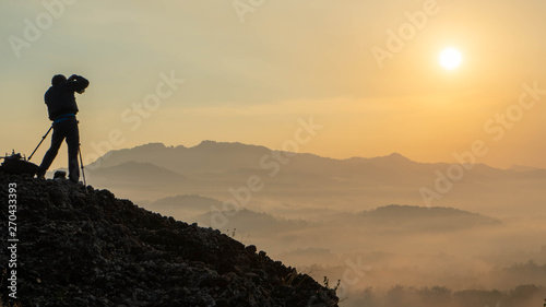 sunrise views in the summer that emerge from the hills in a village with photographer sillhouette