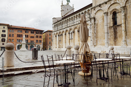 Empty small outdoor restaurant tables on the main square of Lucca, Italy