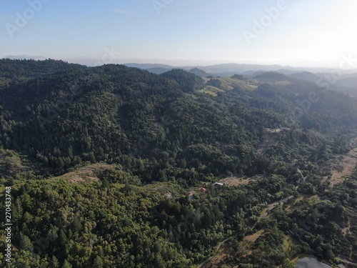 Aerial view of the verdant hills with trees in Napa Valley during summer season. Napa County, in California’s Wine Country, Part of the North Bay region of the San Francisco Bay Area. Vineyard area. © Unwind