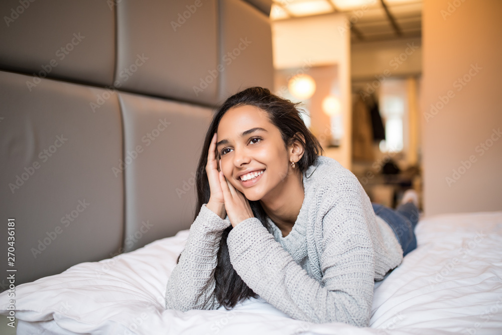 Smiling young pretty woman lying relaxing on the bed Smiling young pretty woman lying relaxing on the bed