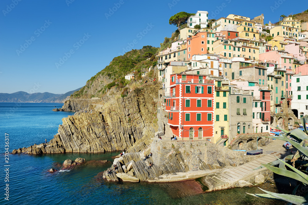 Pastel houses and tiny marina of Riomaggiore, the largest of the five centuries-old villages of Cinque Terre, Italian Riviera, Liguria, Italy.