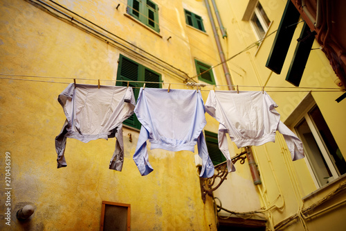 Three shirts drying on a rope in Riomaggiore, the largest of the five centuries-old villages of Cinque Terre, Italian Riviera, Liguria, Italy.