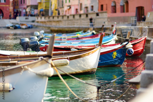 Colourful fishing boats in small marina of Vernazza, one of the five centuries-old villages of Cinque Terre, located on rugged northwest coast of Italian Riviera.