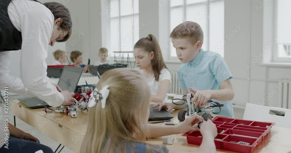 Curious kids working on a functional programable robot during robotics class at school. 4K UHD 60 FPS SLOW MOTION