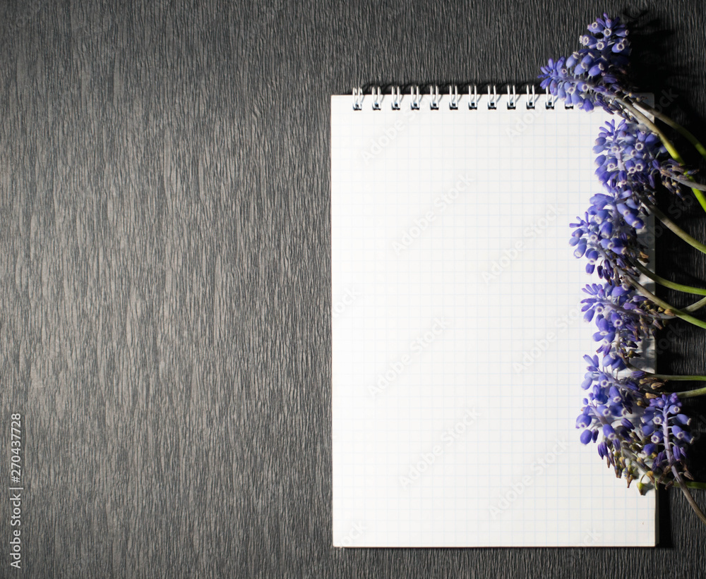 A notepad with field flowers on a black background