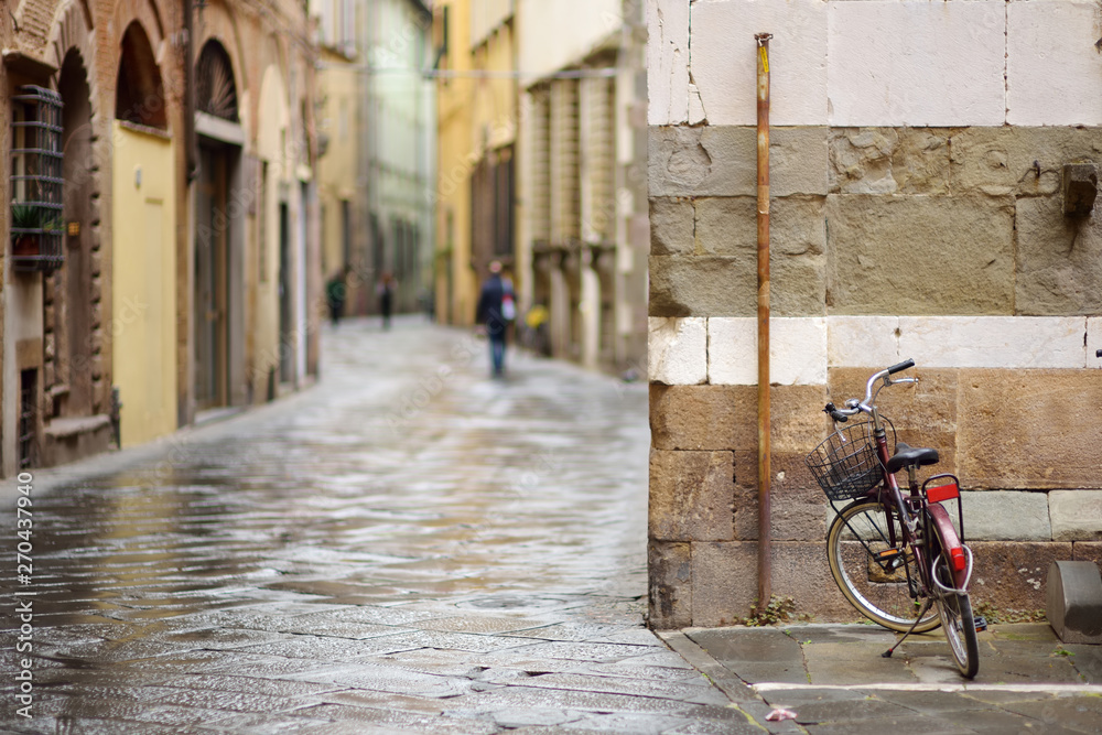 Bicycles parked on beautiful medieval streets of Lucca city, Tuscany, Italy.