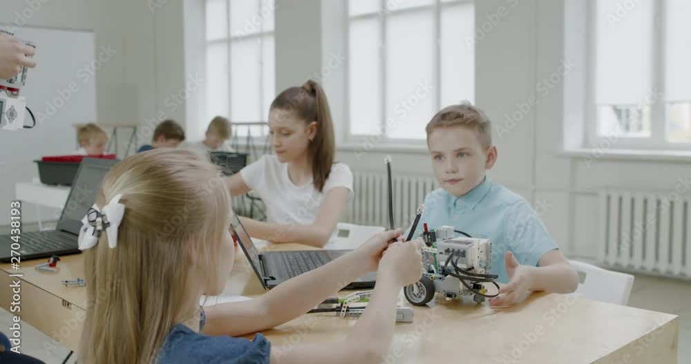 Curious kids working on a functional programable robot during robotics class at school. 4K UHD 60 FPS SLOW MOTION