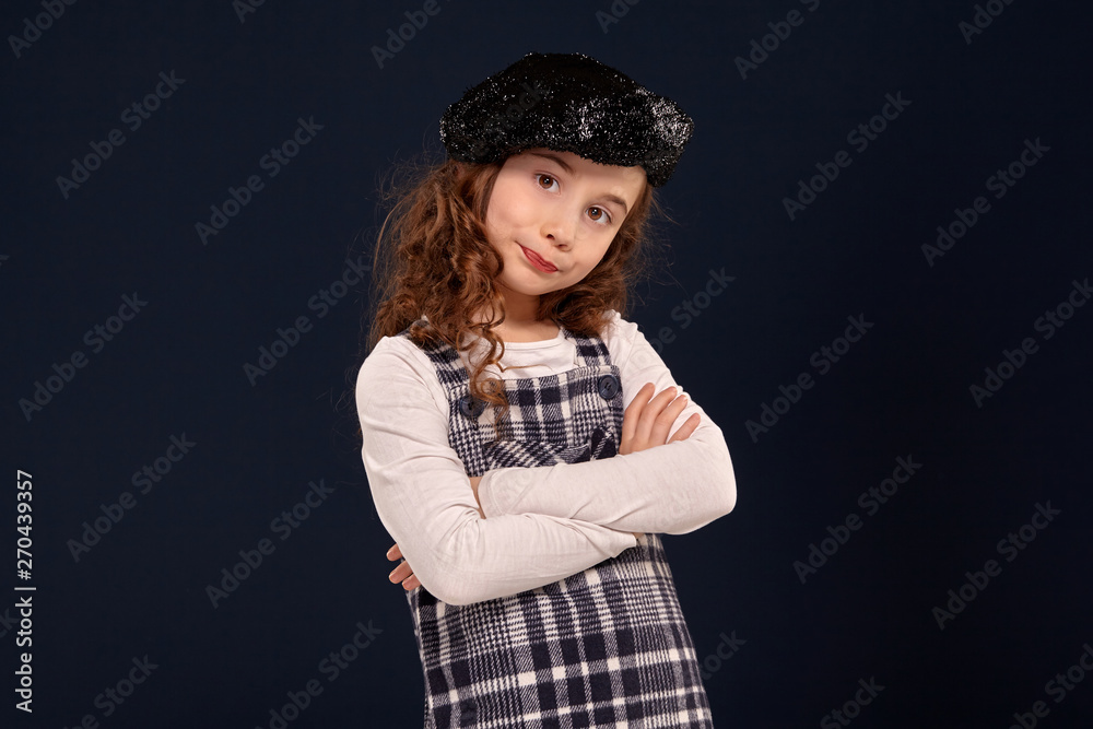 Stylish brunette kid is posing in studio on a black background. Children's fashion. Stylish brunette kid is posing in studio on a black background. Children's fashion.