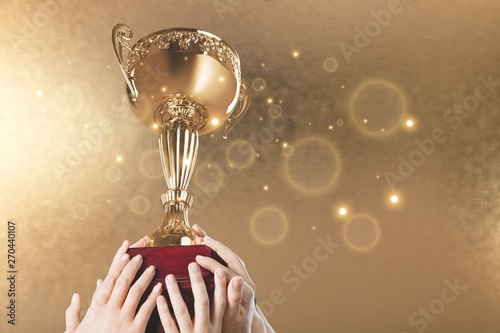 Hands holding golden trophy on a white background