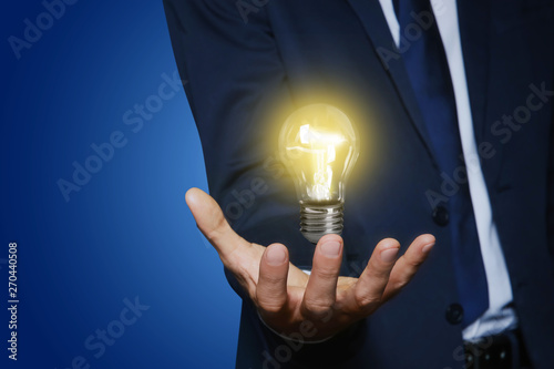 Businessman holding something on color background, closeup view of hand with space for text