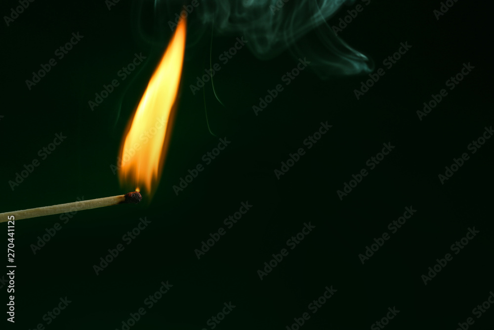 Burning matchstick on color background, closeup. Space for text