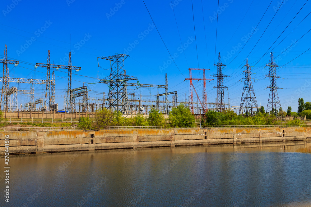 High voltage power lines towers on a riverbank
