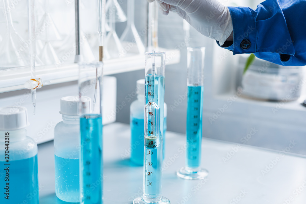 Analysis of the quality of liquids in a chemical laboratory, a device with equipment made of glass with a blue liquid