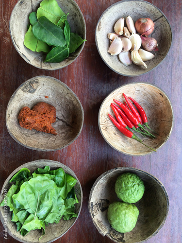 Authentic Thai red curry with ingredients in coconut shells.