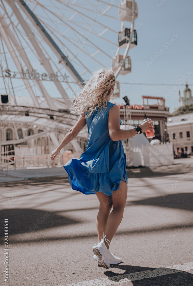 Naklejka premium Woman happy running in summer dress. Italy. Lifestyle. Girl smiling laughing joyful having fun. Walking on city street. Sundress. Fashion. Urban style