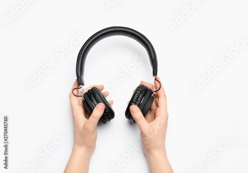 Woman holding stylish headphones on white background, closeup