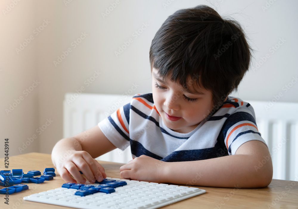 Preschool boy playing English upwords game, Smart kid playing upwords game letter with parent at home. Activity for children for play and learn concept Preschool boy playing English upwords game, Smart kid playing upwords game letter with parent at home. Activity for children for play and learn concept