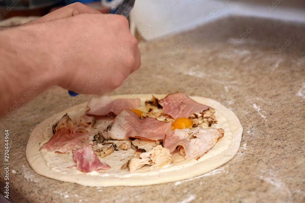 Man preparing pizza at table, closeup. Oven recipe