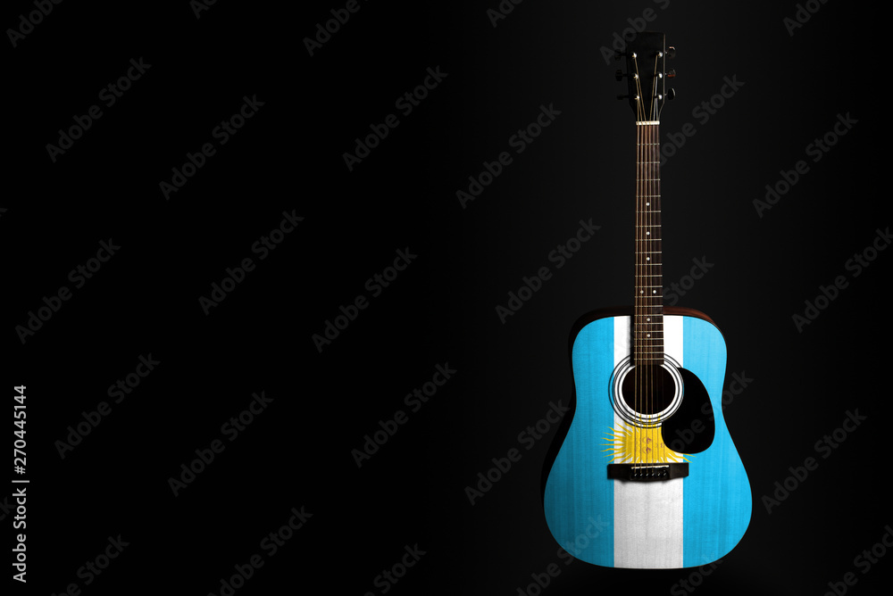 Acoustic concert guitar with a drawn flag Argentina, on a dark background, as a symbol of national creativity or folk song.
