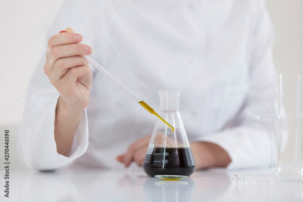 Scientist tearing the CBD oil with a precise dropper from a bowl into a tube Scientist tearing the CBD oil with a precise dropper from a bowl into a tube