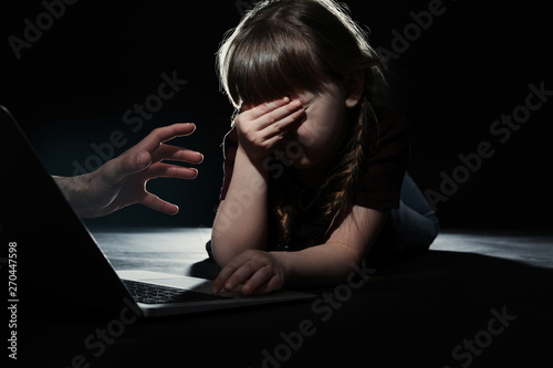 Photos Stranger reaching frightened little child with laptop on dark background