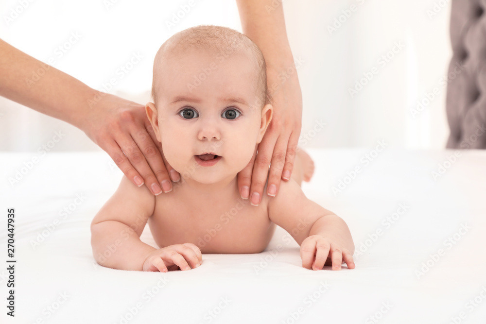 Mother and her cute child on bed indoors, space for text. Baby massage and exercises Mother and her cute child on bed indoors, space for text. Baby massage and exercises