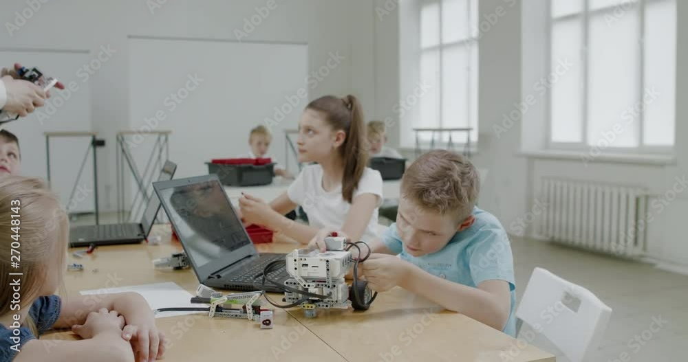 Curious kids working on a functional programable robot during robotics class at school. 4K UHD 60 FPS SLOW MOTION