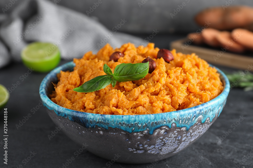 Bowl with mashed sweet potatoes on grey table Bowl with mashed sweet potatoes on grey table