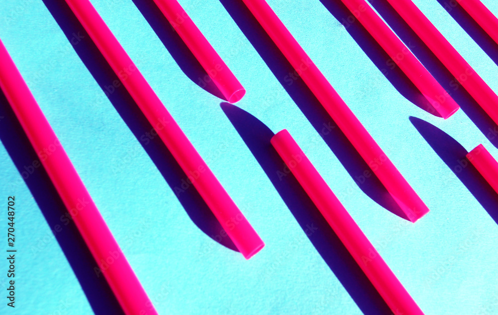 Obraz premium Summer party sun shine bright red and pink cocktail tube on blue background