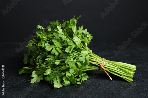 Fotografie Bunch of fresh green parsley on dark table
