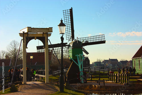 spring trip to Zaanse Schans. Placid channels, tranquil rivers flow between the hills. The Dutch windmills stand as a traditional tourist landmark after centuries