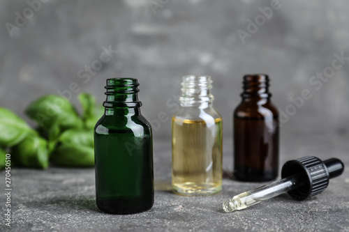 Different bottles with essential oils and dropper on table
