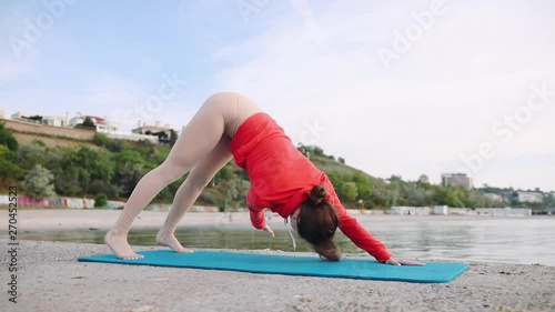 Handsome female making ekapada pranamasana pose in hatha yoga asana photo